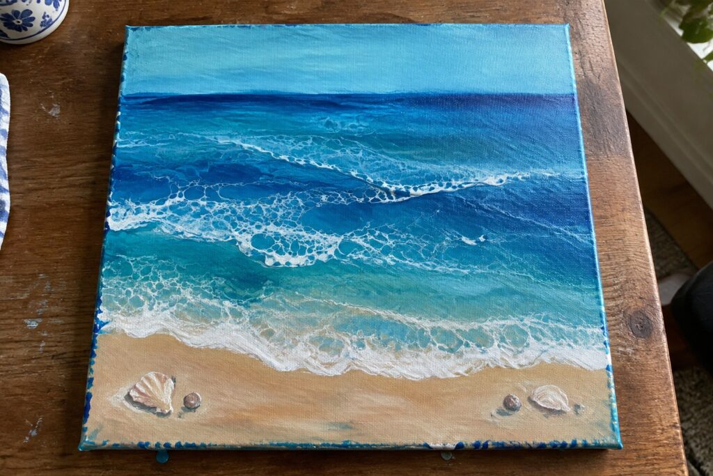 19 Innovative Acrylic Pour Ocean Painting Ideas for Fluid Water Effects Acrylic seascape painting of blue ocean waves with white foam on sandy beach with seashells.