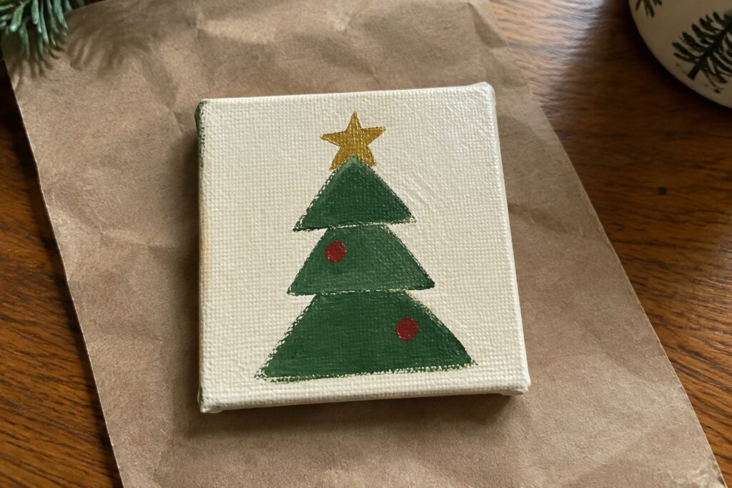 Small square canvas with green Christmas tree, yellow star, red ornaments, and brown trunk