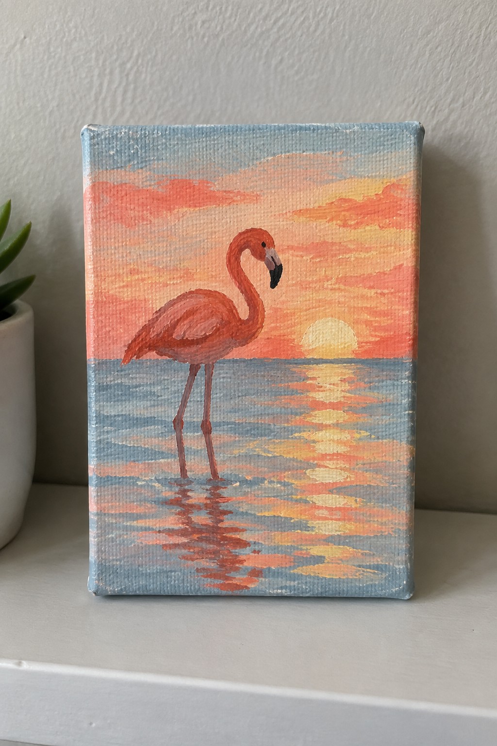 Canvas painting of pink flamingo standing in reflective water under vibrant sunset sky