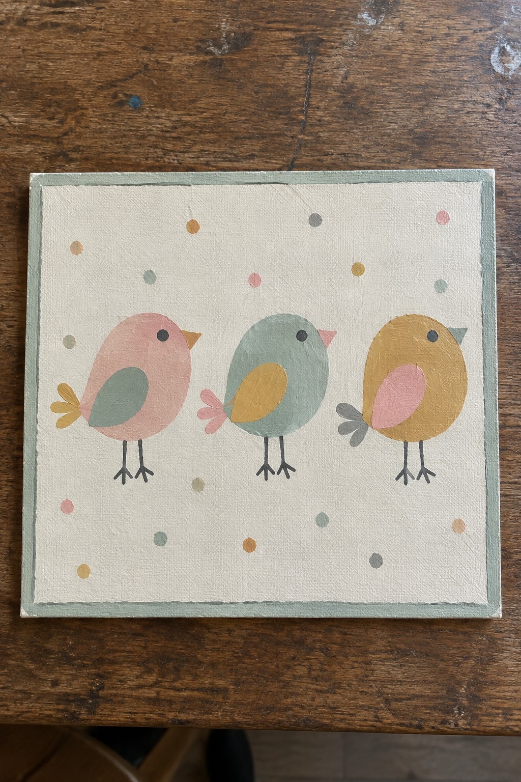 Three pastel birds on polka-dotted canvas with light green border.