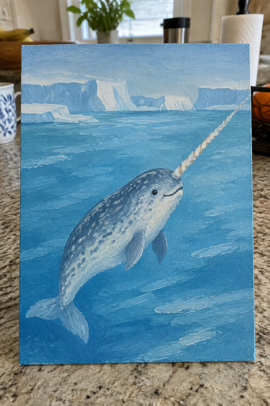 Blue-toned painting of a narwhal with spiraled tusk swimming in Arctic waters.