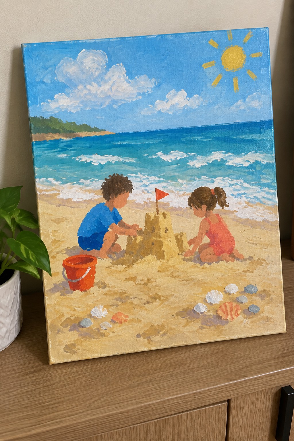 Children building sandcastle on sunny beach with blue ocean, waves, shells, and red bucket