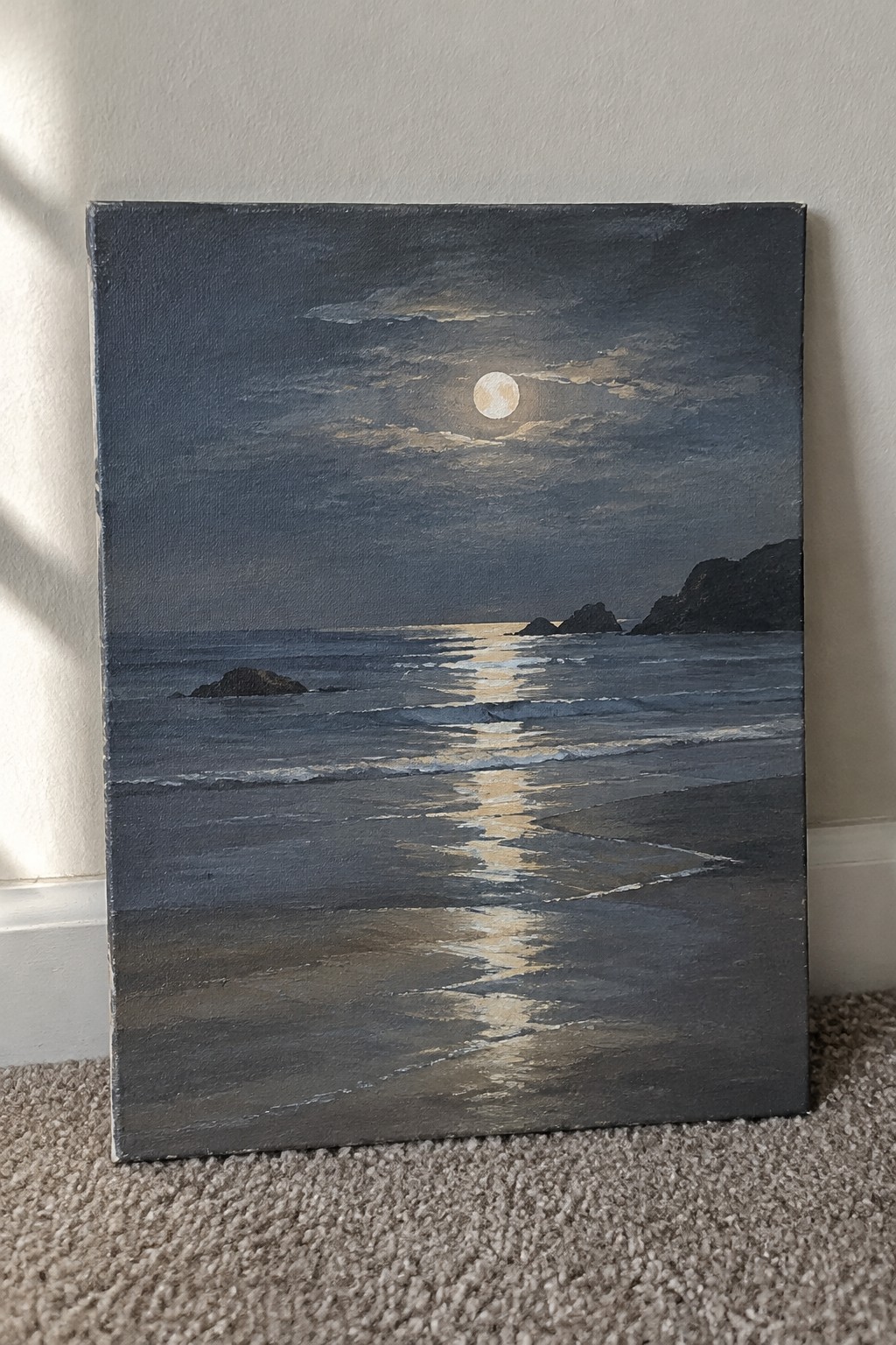 Nocturnal seascape painting of moonlit waves reflecting on dark sandy beach with cliffs.