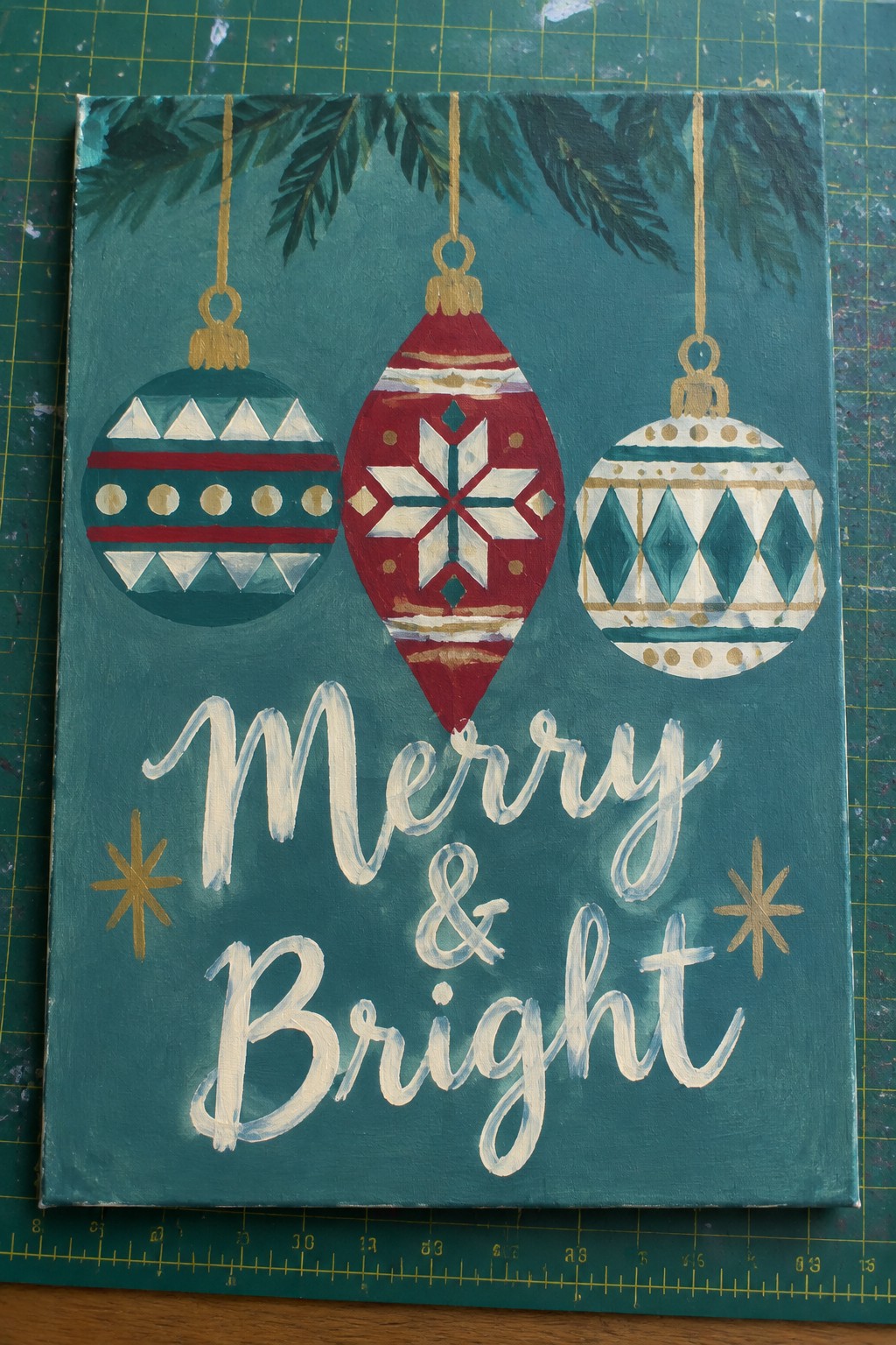 Three festive Christmas ornaments hang above 