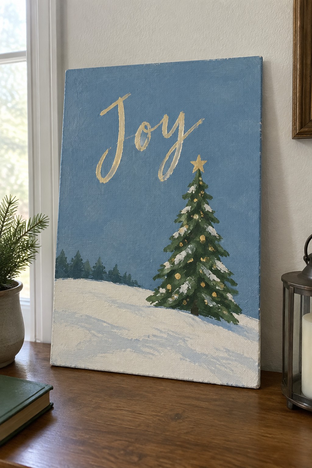 Canvas painting of snowy Christmas tree with gold ornaments and cursive 