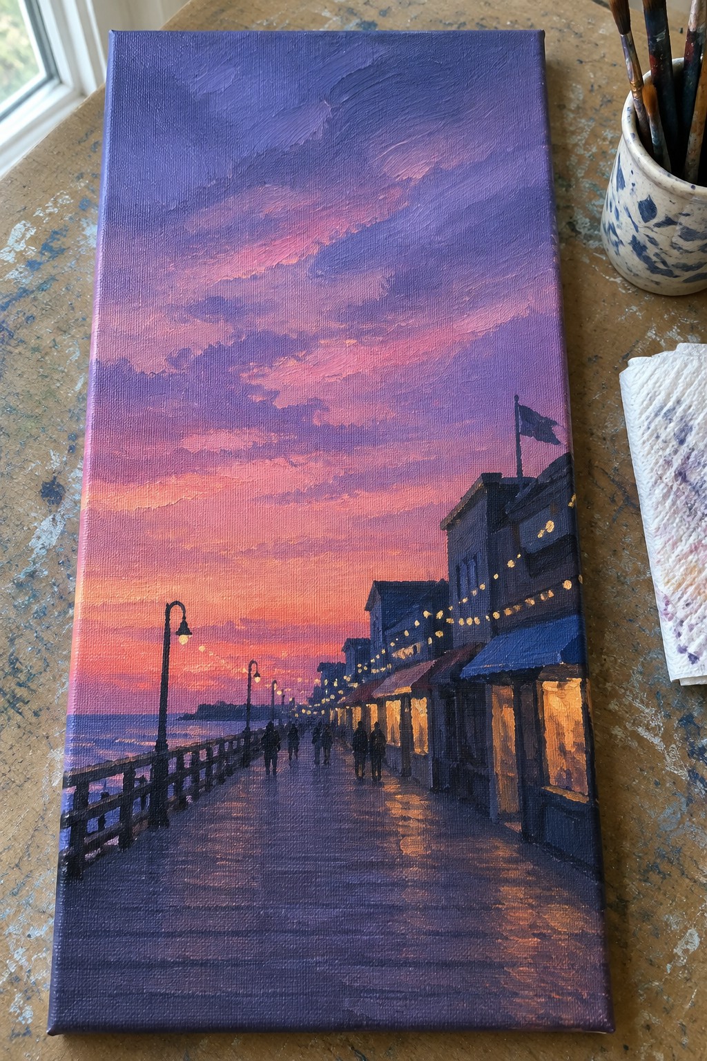 Vibrant purple-pink sunset over glowing boardwalk with shops, lights, and walking figures.