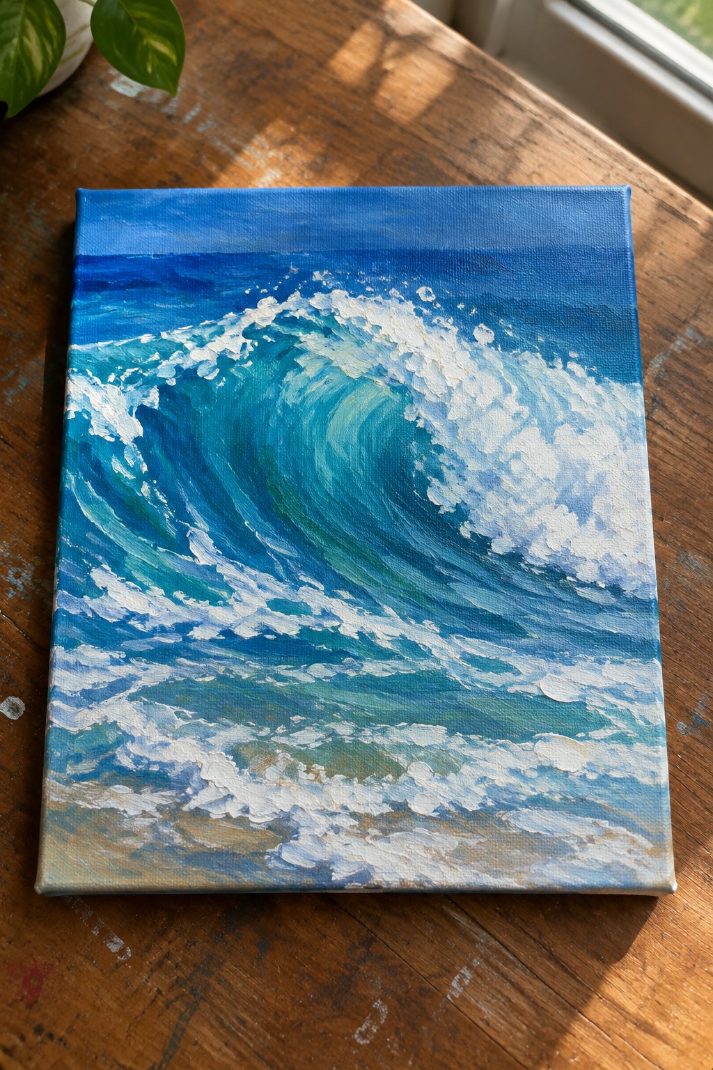 Curling blue ocean wave with white foam on canvas atop wooden table