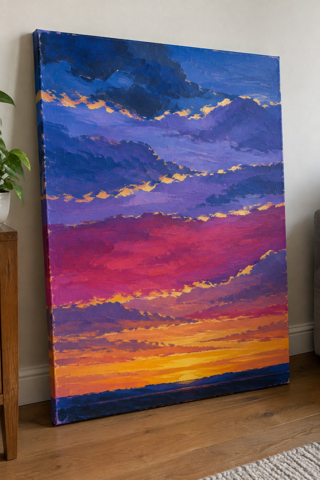 Vibrant impasto sunset painting in blues purples pinks oranges leaning on wooden floor