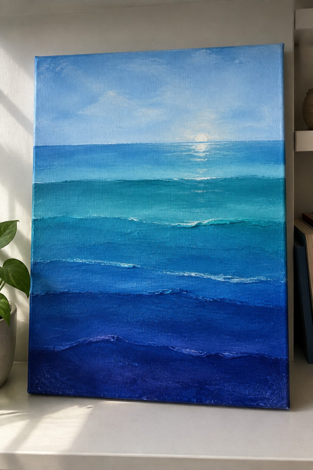 Seascape painting on canvas with layered blue ocean waves and sun reflection