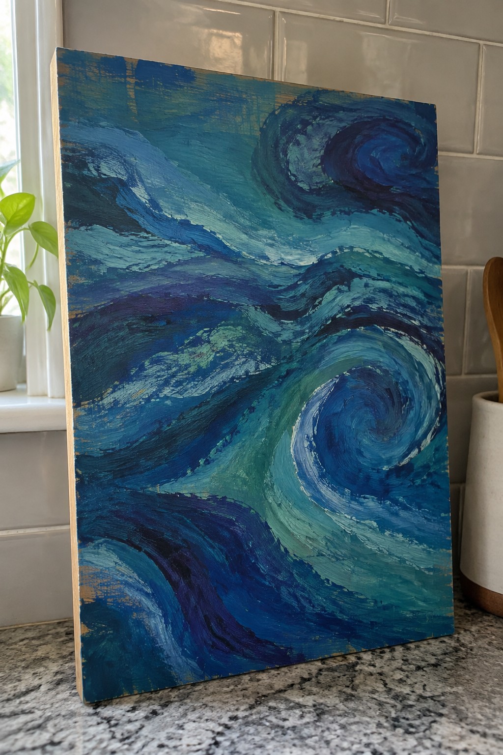 Abstract painting with swirling blue green teal waves on canvas in kitchen