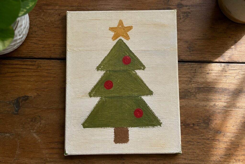 Stylized Christmas tree painting with stacked green triangles, red ornaments, and yellow star.