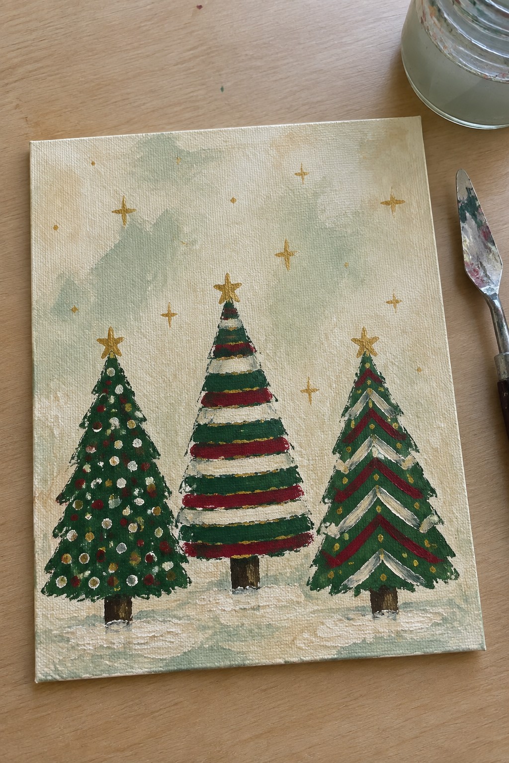 Three Christmas trees with stars and ornaments painted on canvas with snow