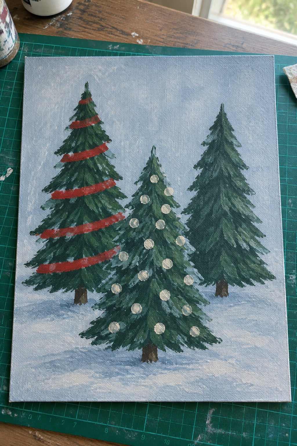 Canvas painting of three Christmas trees in snow with red stripes and white ornaments