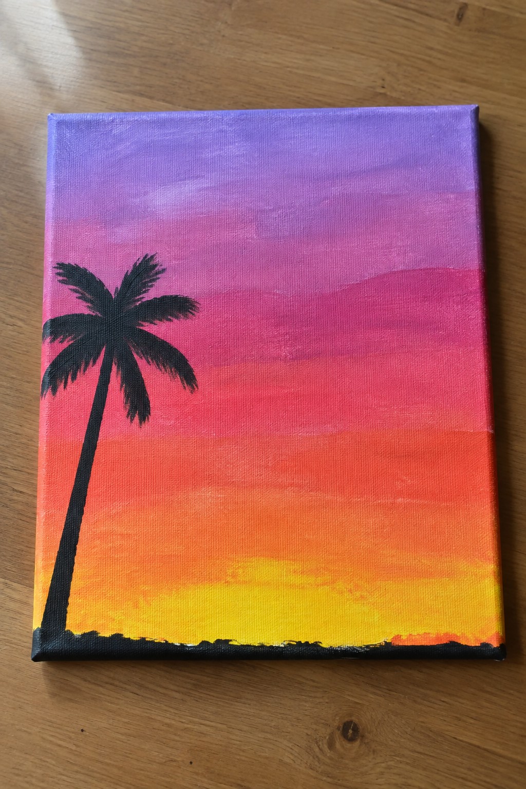 Canvas painting of silhouetted palm tree against purple pink orange yellow sunset gradient