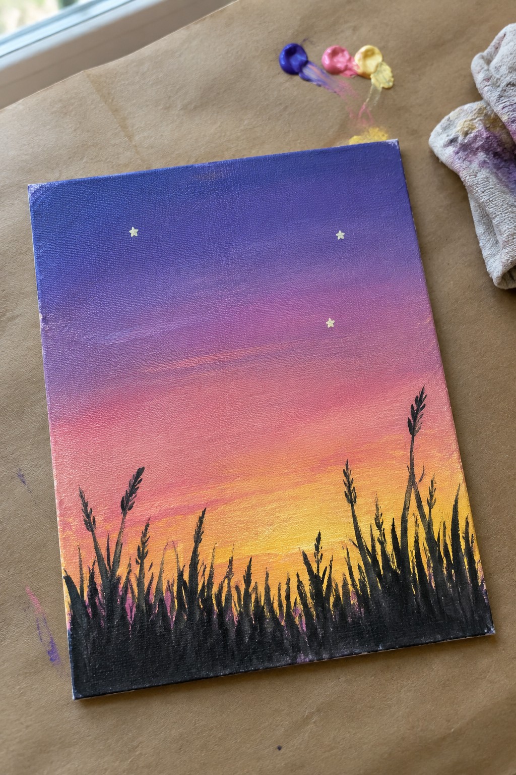 Canvas with purple-pink-orange gradient sky, stars, and black grass silhouettes