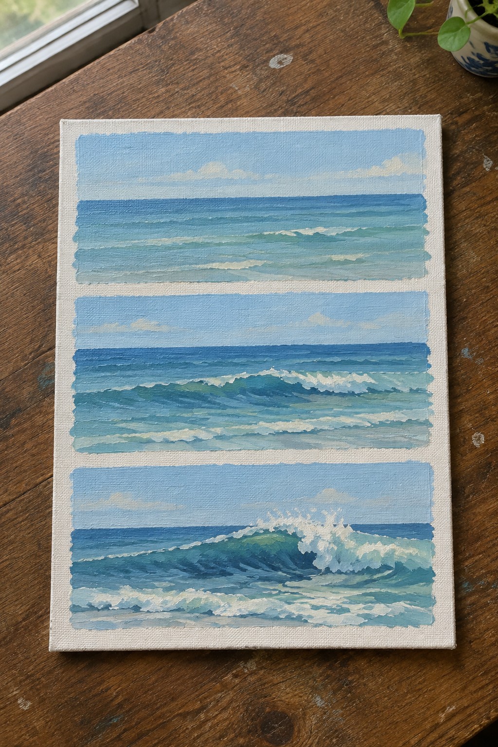 Three-panel seascape painting of ocean waves on wooden table
