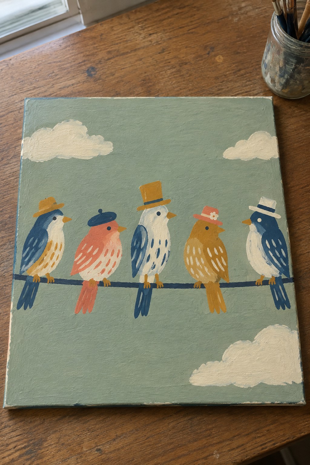 Five colorful birds in hats perch on a wire against a cloudy green sky
