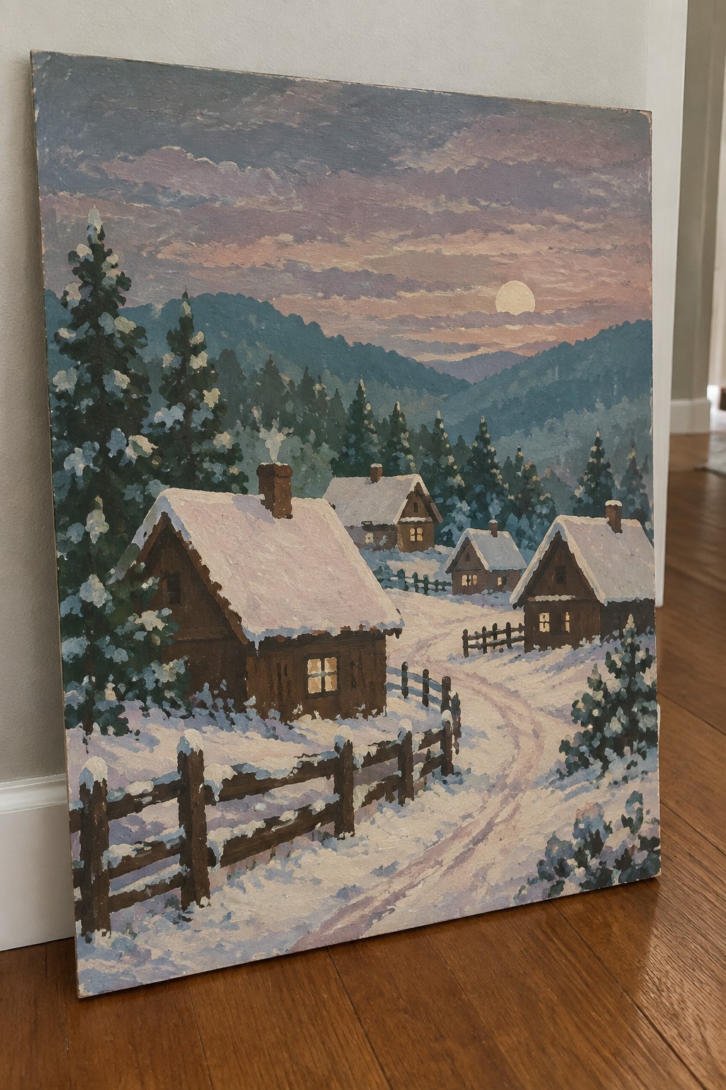 Snowy mountain village painting with wooden cabins, fences, pine trees, and glowing sunset.